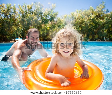Child with dad playing in pool. Summer vacations