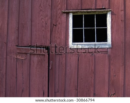 A detailed view of an old wooden barn side and window.