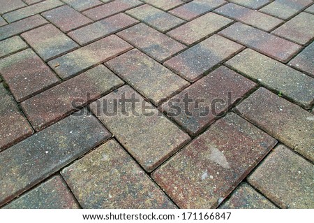 Red and Yellow pavers or bricks laid in a criss cross pattern fills the frame.