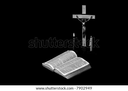 stark black and white image of a prayer crucifix with two candles set out before a bible open to the book of Jeremiah