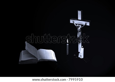 stark somber blue toned image of a prayer crucifix with two candles set out before a bible open to the book of matthew