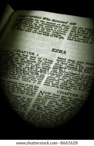 bible series, detail of an old antique holy bible against a black background open to the book of ezra old testament finished in sepia