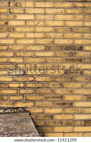 yellow brick wall background with ledge of cement connected to it