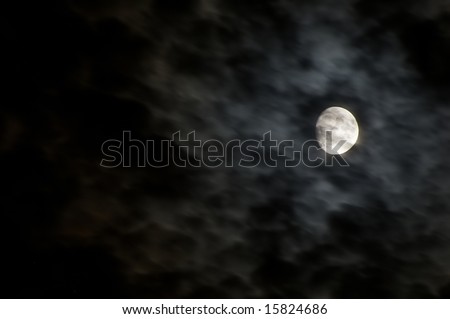 clouds moving rapidly across the sky in front of a three quarter full moon