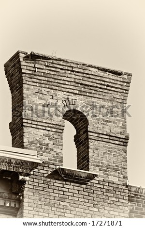 old brick arch high in the sky finished in sepia