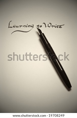 learning to write being written in calligraphy on parchment paper with pen finished in monotone