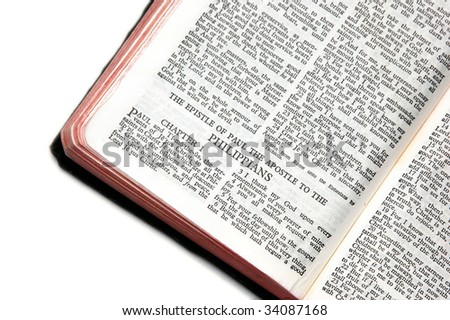 holy bible open to the epistle of paul the apostle to the philippians, against a white background