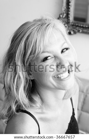looking down towards a beautiful blonde woman that is looking at viewer and laughing , black and white image