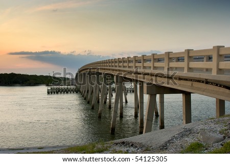 a cement bridge arches over the bay that leads from bonita springs to ft. myers in southwest florida at sunset