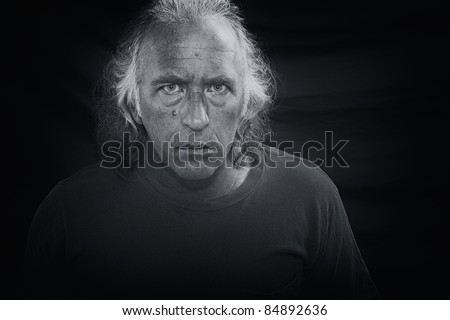 Black and white portrait of a scary looking man staring directly at viewer.