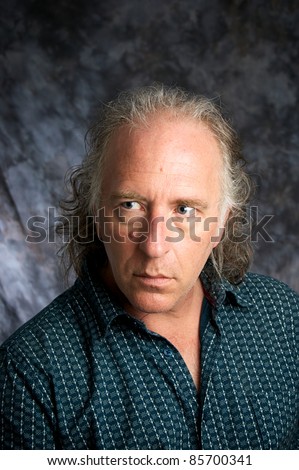 A handsome mature white american male in studio looking to the side.