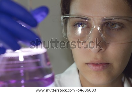 scientist using a light scope examination to analyze a chemical