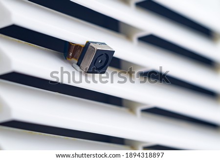 Spy hidden micro camera in the ventilation grill. Spy scandal, collecting compromising evidence, symbolic image Stock fotó © 