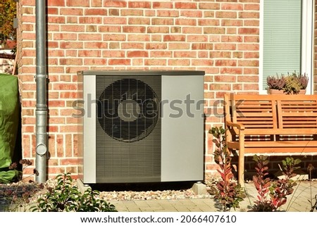 Air conditioner, Air-Air Heat Pump for Heating and hot Water in Front of an Residential Building Imagine de stoc © 