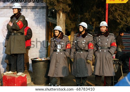 BEIJING - JANUARY 31: Chinese security guards are watching the crowds, visiting the Spring Festival Fair in Ditan Park in Beijing on January 31, 2009.