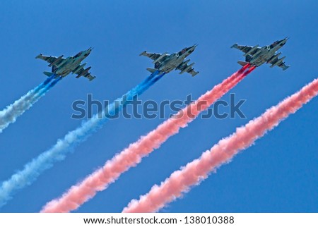 MOSCOW - MAY 09: three Sukhoi Su-25 attack planes fly with smoke trails during during the parade in honor of WWII Victory on May 09, 2013 in Moscow, Russia