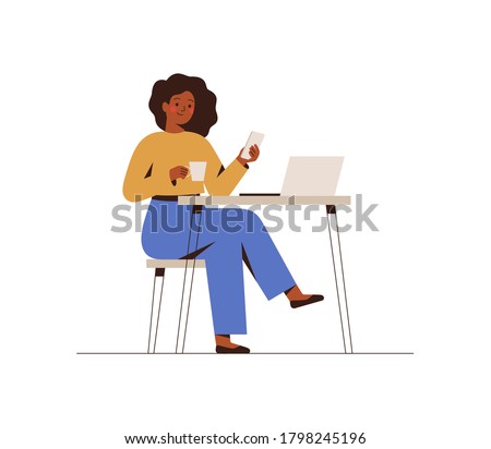 Black Woman chatting on a smartphone sitting at the cafe table. Happy freelancer or office female working remotely use a laptop. African girl looking at the phone, drinking coffee at the workplace.