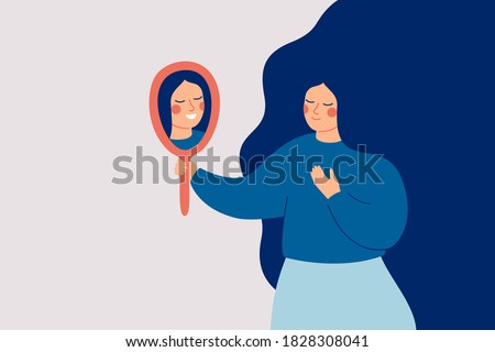 Young woman looks at the mirror and sees her happy reflection. Self-acceptance and confidence concept.