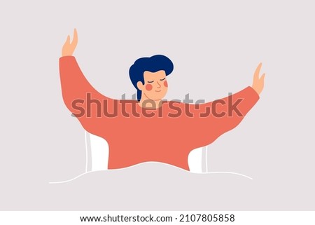 Happy man wakes up and feels good yourself. Smile boy makes morning stretch in the bed. Body positive and health care concept. 