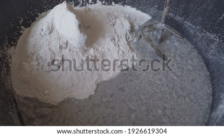 Putty - stir in black bucket. Black bucket with white putty mixture. Building mixture in a bucket. Foto stock © 
