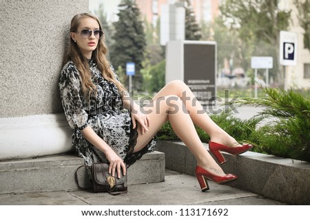 Beautiful woman sitting at column