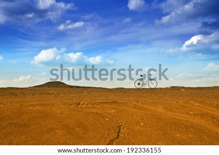 Ends of the earth. Bike in desert at sky background.