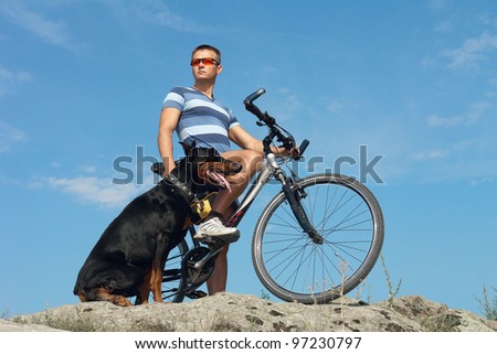 Bike ride. A young man on a bicycle with a dog