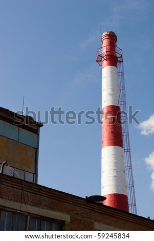 Pipe of a boiler-house against the blue sky