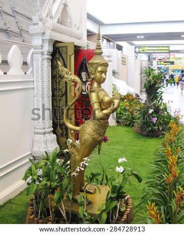 BANGKOK, THAILAND - OCTOBER 18, 2013:interior of airport Don Muang, golden statue of buddhistic idol.