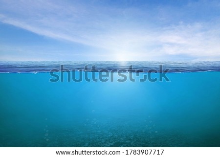 BLUE UNDER WATER waves and bubbles. Beautiful white clouds on blue sky over calm sea with sunlight reflection, Tranquil sea harmony of calm water surface. Sunny sky and calm blue ocean. 
