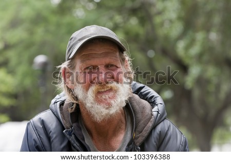 Happy old homeless man smiling