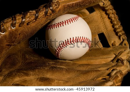 New baseball resting in old worn glove