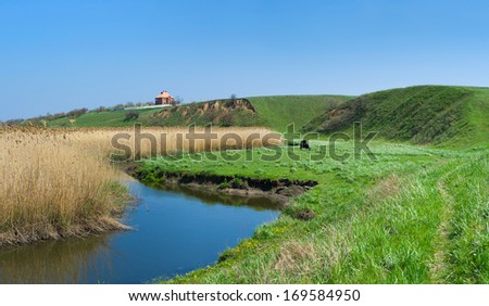 Rural landscape with small Ukrainian river Sura at early spring season.