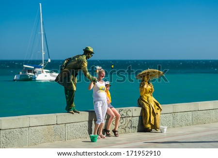 Yalta, Ukraine - May 25, 2013: Human statues (live artists) on the sea-front earn some money letting campers to take photographs with them.