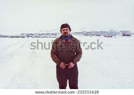 Chukchi Peninsula, USSR - March 25, 1979:Outdoor portrait of young soviet gold-prospector against settlement Komsomolskiy near Pevek, most northern town in USSR