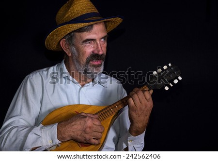 Portrait (low key) of an old country man with mandolin