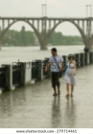 Blurry background - empty embankment, rain, loving couple