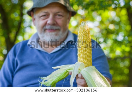 Positive portrait of Ukrainian farmer showing quality of his maize harvest