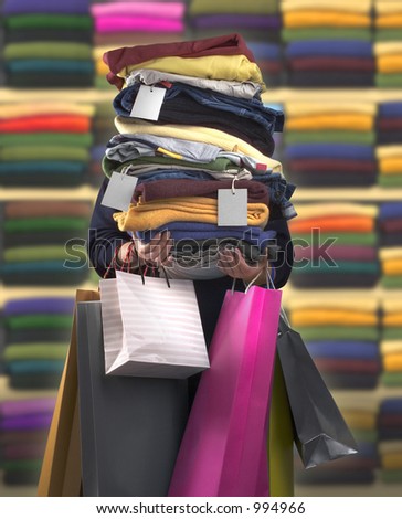Woman carrying bags and a pile of clothes with tags