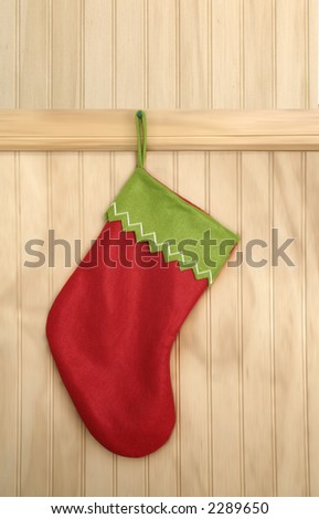 Red Christmas boot hanging over a wooden wall waiting for Santa Claus