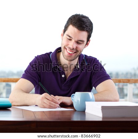 Young man happily writing a letter by hand