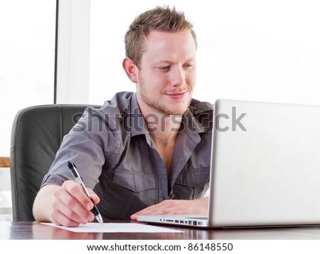 Creative worker smiling as he works on his laptop