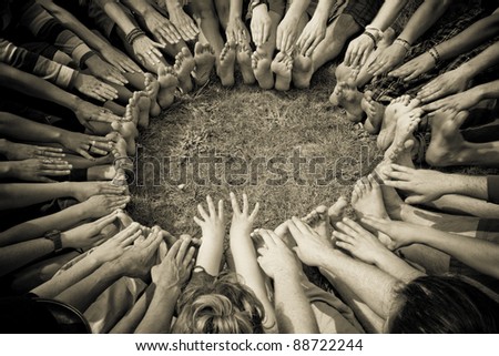 Group of people in a circle stretch and reach for their toes