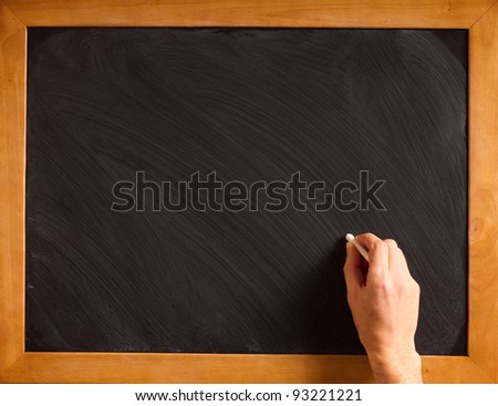Male hand writing with chalk on a clean blackboard - add your own chalk!