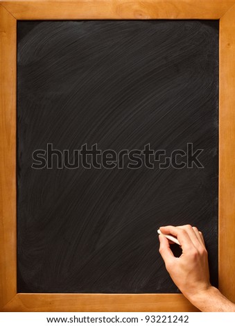 Male hand writing with chalk on a clean blackboard - add your own chalk!