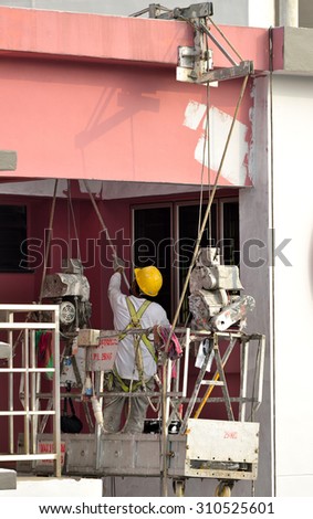 SINGAPORE - JUNE 25: Workers painting the exterior walls on June 25, 2015 in public housing block. About 90% of resident households owning their HDB flat in Singapore.
