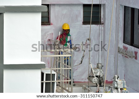 SINGAPORE - JUNE 25: Workers painting the exterior walls on June 25, 2015 in public housing block. About 90% of resident households owning their HDB flat in Singapore.