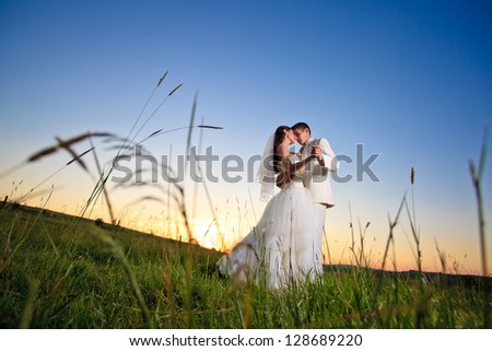 Wedding couple dansing in mountain hill on sunset