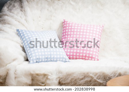 Pillows on the sofa with white fur