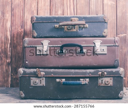 Vintage suitcases over wooden wall, retro style